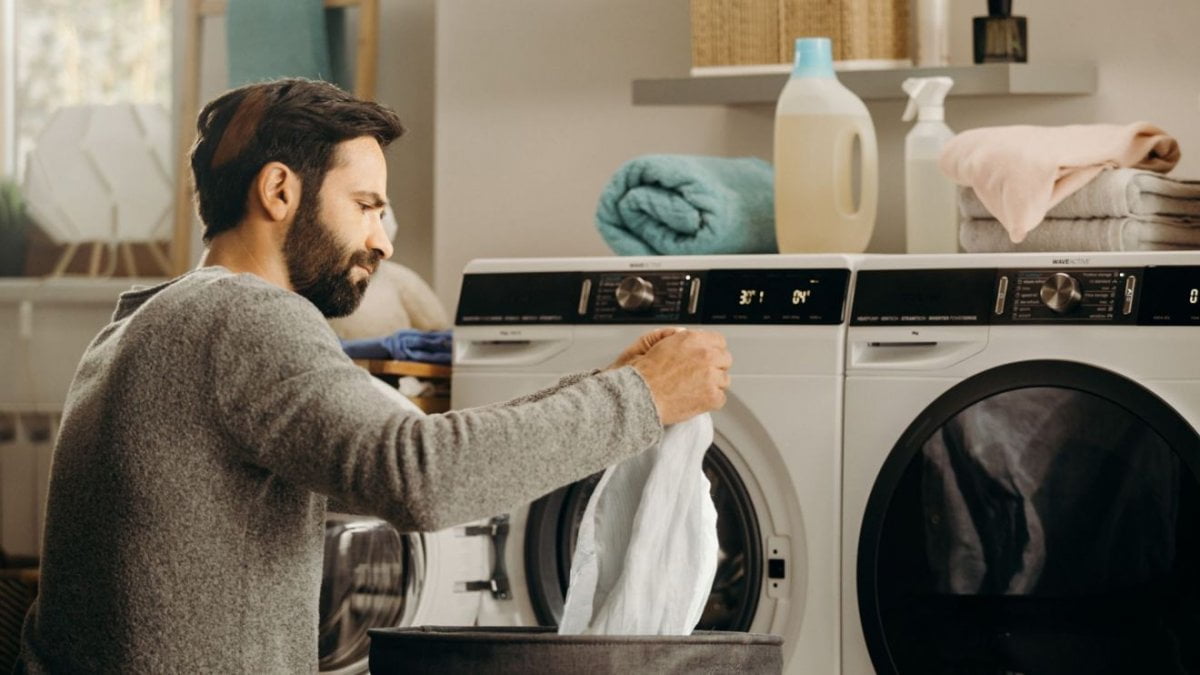 Un homme qui trie son linge avant de le mettre dans sa nouvelle machine à laver