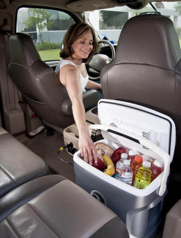 Une glacière électrique bien remplie avec des fruits et des boissons dans une voiture