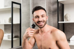 Homme qui utilise une tondeuse à barbe